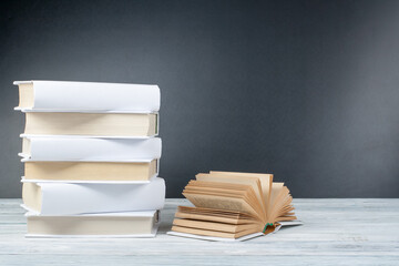 Open books on wooden table, black board background. Back to school. Education business concept.