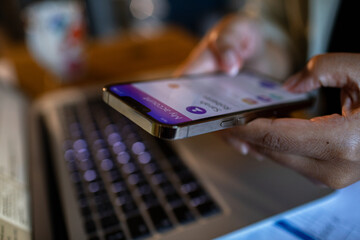 Young woman using a banking app on her phone to check her bills and finances