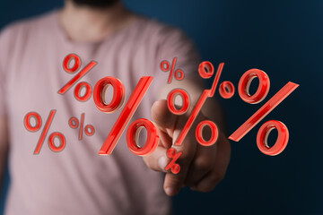 Hand pointing at floating percentage symbols representing financial growth, sale, and discount....