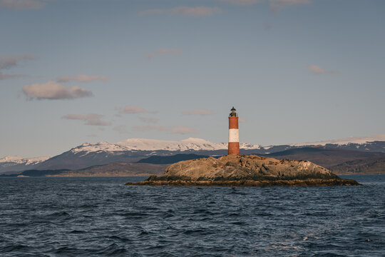 Paisaje del islote Les Eclaireurs en Tierra del Fuego con el faro tradicional en la tarde. Al fondo los andes nevados. Patagonia argentina. 