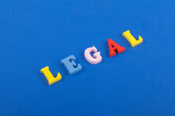 Obraz premium LEGAL word on blue background composed from colorful abc alphabet block wooden letters, copy space for ad text. Learning english concept.