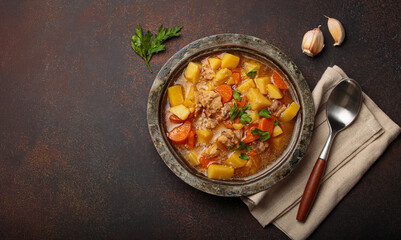 Hot chicken stew or soup with tender chicken pieces, chunky potatoes, and vibrant carrots garnished...