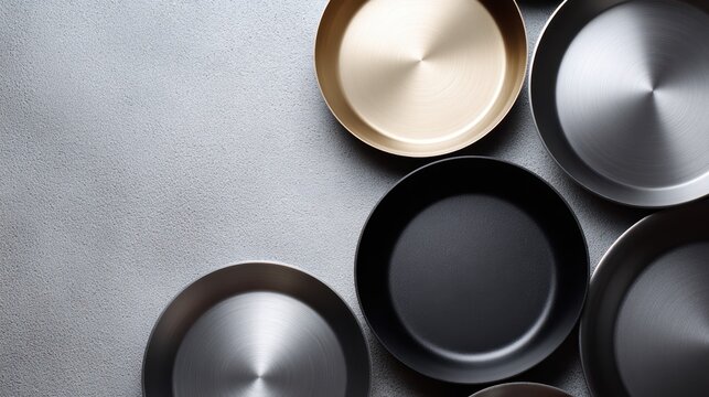 Top view of assorted metallic cooking pans, ideal for recipe photography or cooking tutorial mockups.