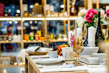 Table setting with amber glass and white ceramics in a decor store in a shopping mall