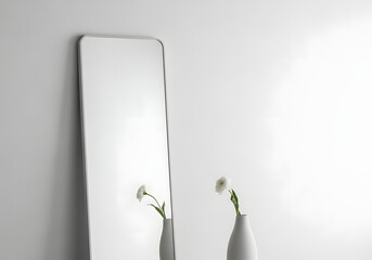 Minimalist full length mirror with white flower against white wall