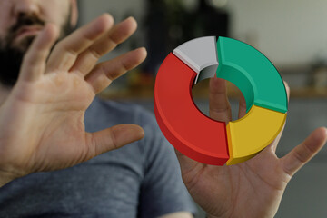 Business concept of data analysis with a man holding a colorful 3D pie chart, representing market share and financial progress.
