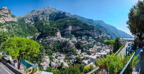 Panoramic elevated view of the cliffside village of Positano on Italy’s Amalfi Coast, with houses nestled against dramatic mountains under a clear blue sky