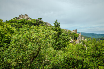 Landscape view of the Moorish Castle (Castelo dos Mouros) on a lush green hill in Sintra, Portugal, a 10th-century fortification - 1