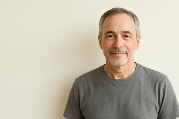 Obraz premium Confident mature man with a friendly smile. Portrait against a plain background with copy space, perfect for a trustworthy commercial proposal.