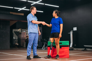 A female patient with a prosthetic leg receiving support from a physiotherapist during rehabilitation exercise, symbolizing recovery, care, and teamwork in modern medical and fitness therapy.