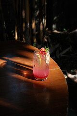 Refreshing pink lemonade with fruit garnish on a rustic wooden table beckons on a hot summer day, promising pure refreshment and relaxed moments