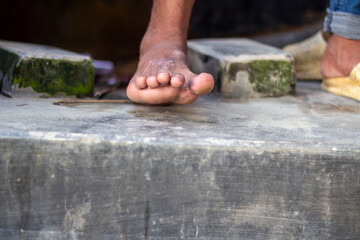 Closeup of a bare foot stepping onto a textured concrete surface