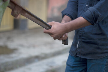 Mans hands operating an old water pump handle