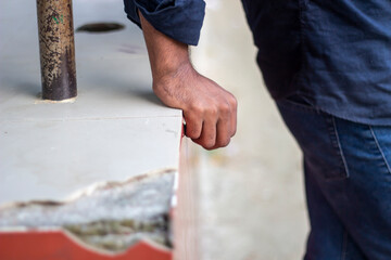 Mans hand gripping the edge of a concrete surface