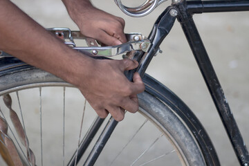Persons hands fixing a bicycle tire with a tool