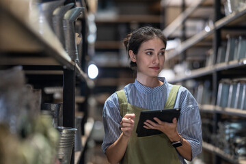 Fototapeta premium A Female Entrepreneur in a Family Run Ceramic Business Checking Stock