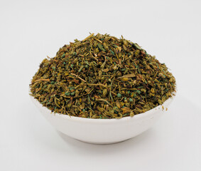 Fototapeta premium Dried Herbal Green Tea Leaves Piled In White Ceramic Bowl For Cooking, Tea, And Wellness