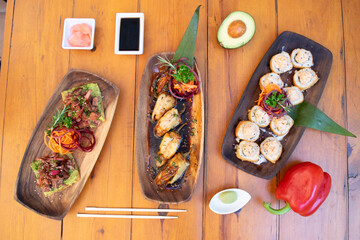 Mesa con muchos platos de sushi y otras comidas asiáticas