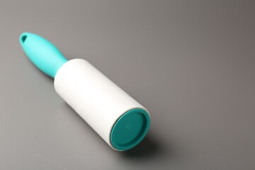 One lint roller on grey background, closeup. Space for text