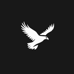 Obraz premium Majestic white eagle or hawk silhouette in graceful flight against a dark background. Powerful and minimalist vector graphic design symbol.