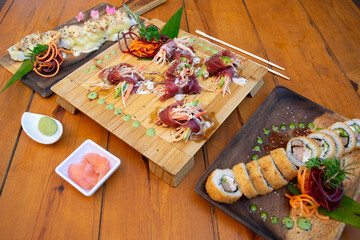 Mesa con muchos platos de sushi y otras comidas asiáticas.