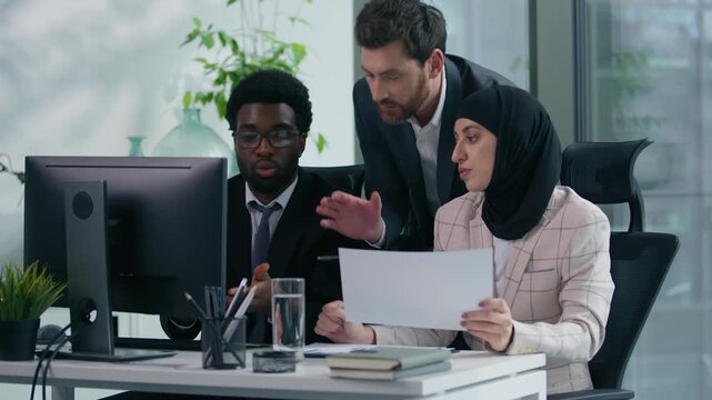 Multicultural business colleagues teamwork in office multiracial three co-workers working together diversity partners talking analyzing data in computer and papers documents meeting brainstorming - Powered by Adobe