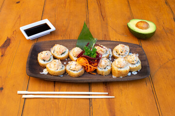 Mesa con muchos platos de sushi y otras comidas asiáticas