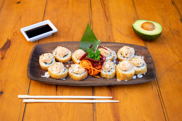 Mesa con muchos platos de sushi y otras comidas asiáticas