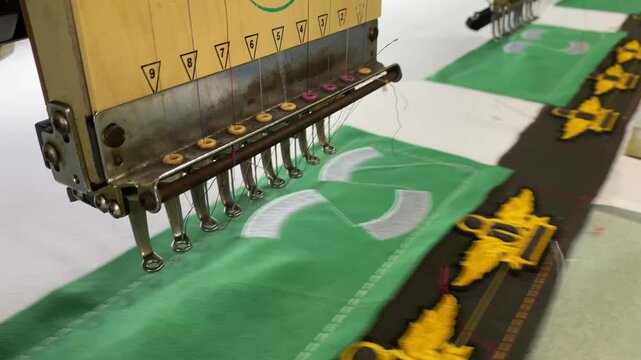 Embroidery machine intricately stitching custom designs onto fabric, creating vibrant patches and emblems with precision and artistry in motion