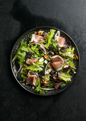 Salad with prosciutto, feta, herbs, nuts and red onion