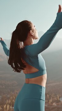 Vertical slow motion close up of woman breathing calmly during yoga at sunrise, symbol of focus, serenity and feminine grace