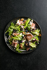 Salad with prosciutto, feta, herbs, nuts and red onion