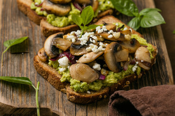Avocado toast with sautéed mushrooms on rustic bread