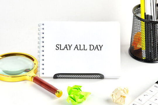 A bright workspace is showcased with a spiral notebook proudly displaying the phrase Slay All Day