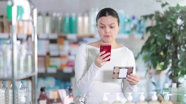 Asian woman stands in a pharmacy and scans the barcode of a package with cosmetics on a mobile camera. Modern payment methods with qr. High quality 4k footage