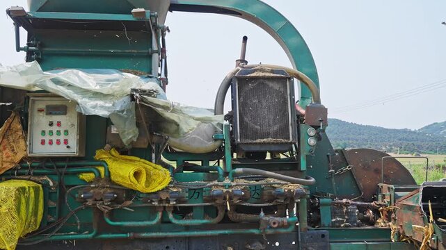 Workers using a machine to crush straw