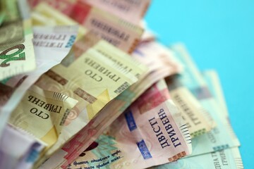 Ukrainian money bills on light blue paper background