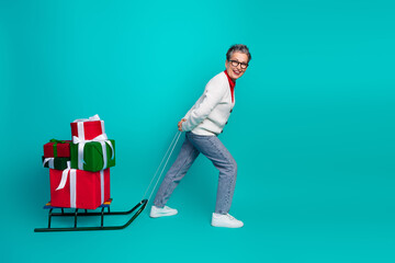 Elderly woman pulls a sled with bright Christmas gifts smiles in a festive holiday scene