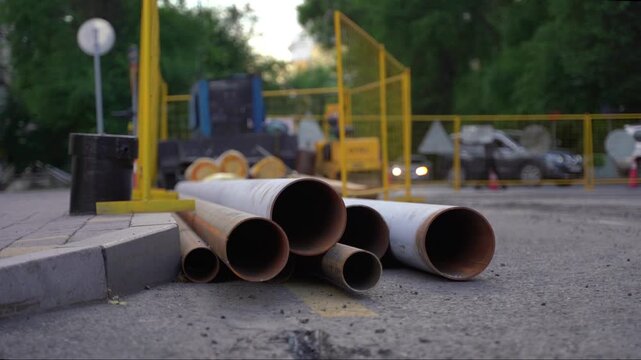 Road work. Reconstruction of the underground pipes on a city street. New metal pipes on the road