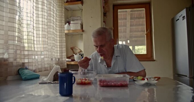 A serene moment as an older gentleman eats a healthy meal, reflecting on life in his cozy home environment. He calmly spoons food from a bowl.