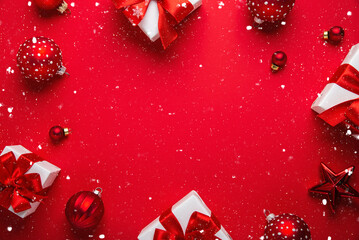 Merry Christmas and Happy Holidays greeting card, frame, banner. New Year. White, red Christmas ornaments and gifts on red background top view. Winter xmas festive holiday theme.