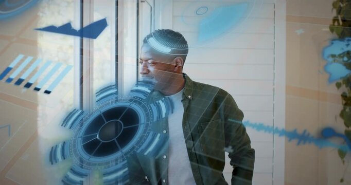 Man gazing outside window and starting tech overlays spinning around torso for analytics