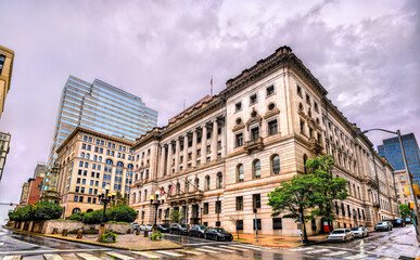 The Clarence M. Mitchell, Jr. Courthouse in downtown Baltimore, Maryland, United States. This historic Beaux-Arts building is seen on a cloudy, rainy day with wet streets reflecting the overcast sky