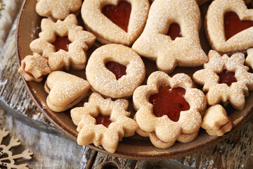 A plate of traditonal Linzer Christmas cookies filled with marmalade and dusted with sugar