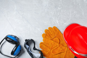 Different safety equipment on light grey marble table, flat lay. Space for text