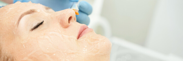 Fototapeta premium Female caucasian adult receiving facial treatment with chemical peel and syringe at spa.