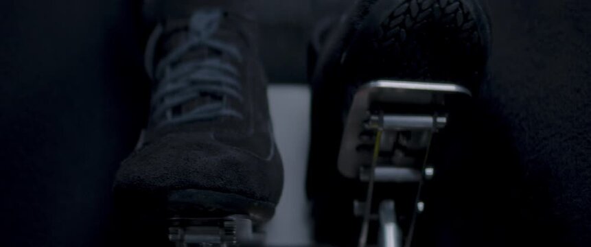 Close-up video of a race car drivers legs and feet engaging the pedals