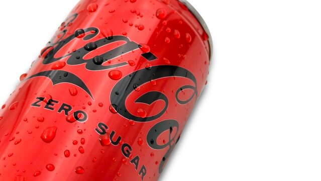 Closeup view of a refreshing Coca-Cola zero sugar soda can with water droplets, isolated on white background with space for text.