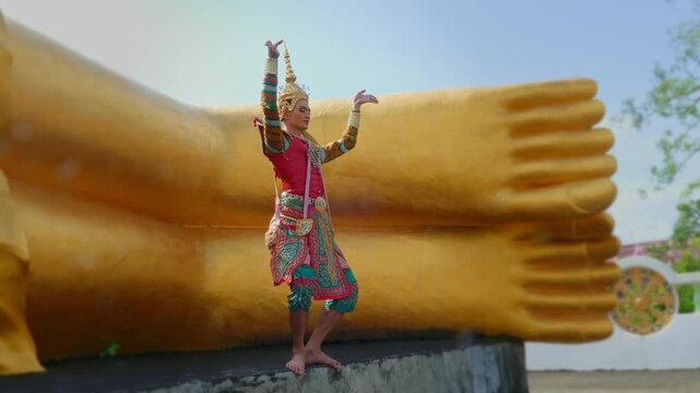 In front of the radiant golden Buddha, a Southern Thai Nora dancer moves elegantly, embodying faith, and art. The vivid colors and rhythmic posture capture the harmony of tradition and devotion.