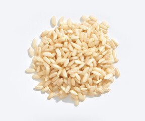 Close-up of uncooked brown rice grains on a white background.
